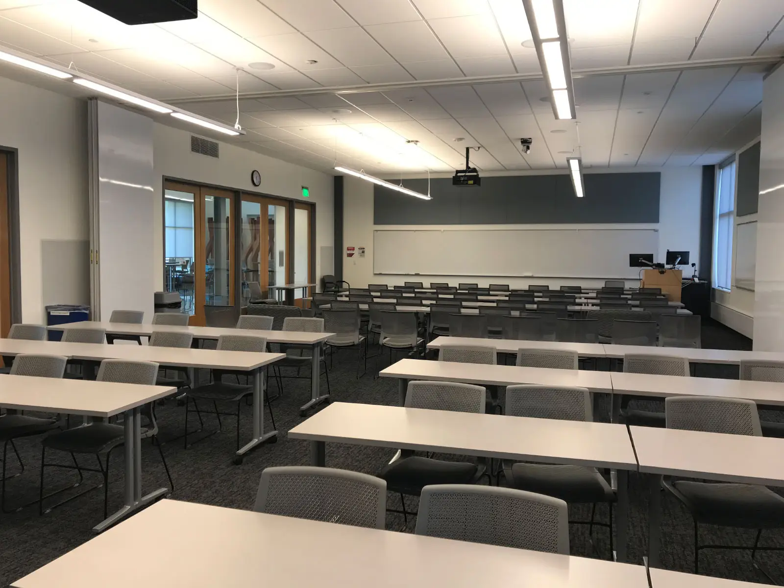 Several separate rows of chairs and tables in front of a podium in a Harmony campus classroom