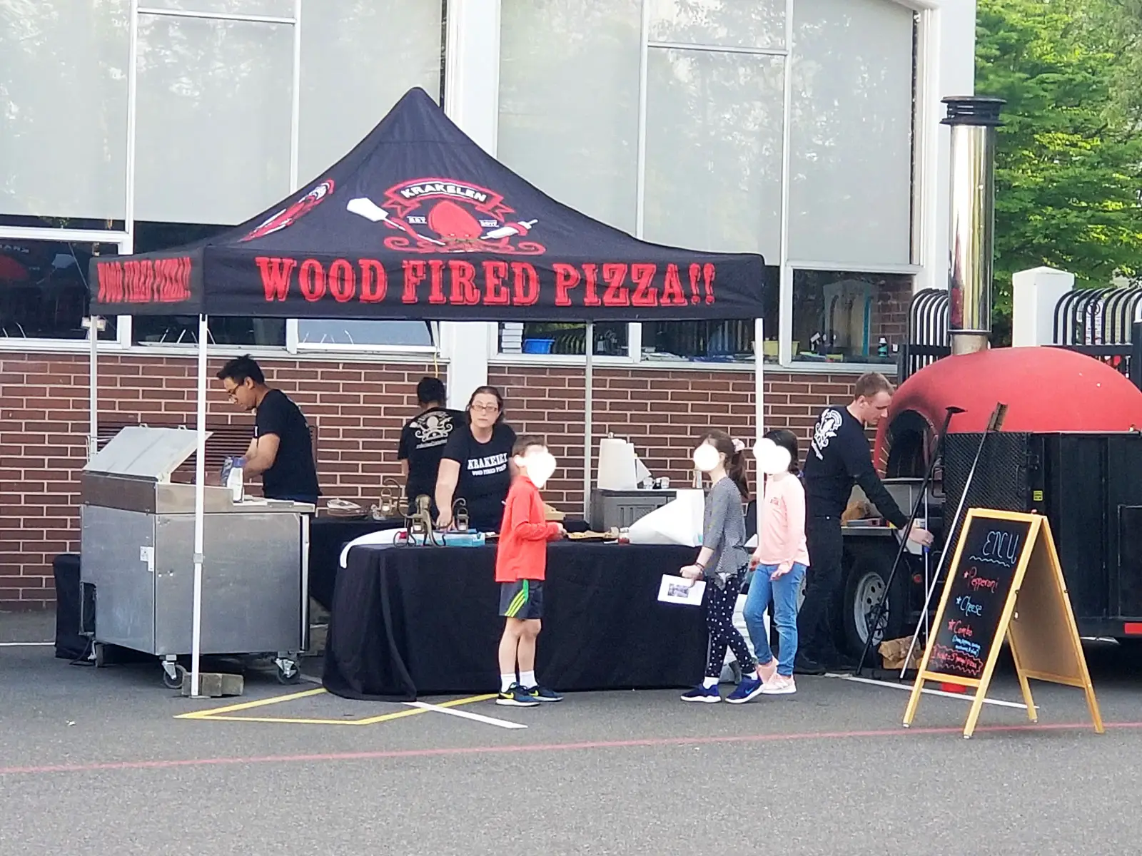 A Krakelen pizza food tent with staff using a grill and wood oven, at the Wilsonville campus A Krakelen pizza food tent with staff using a grill and wood oven, at the Wilsonville campus