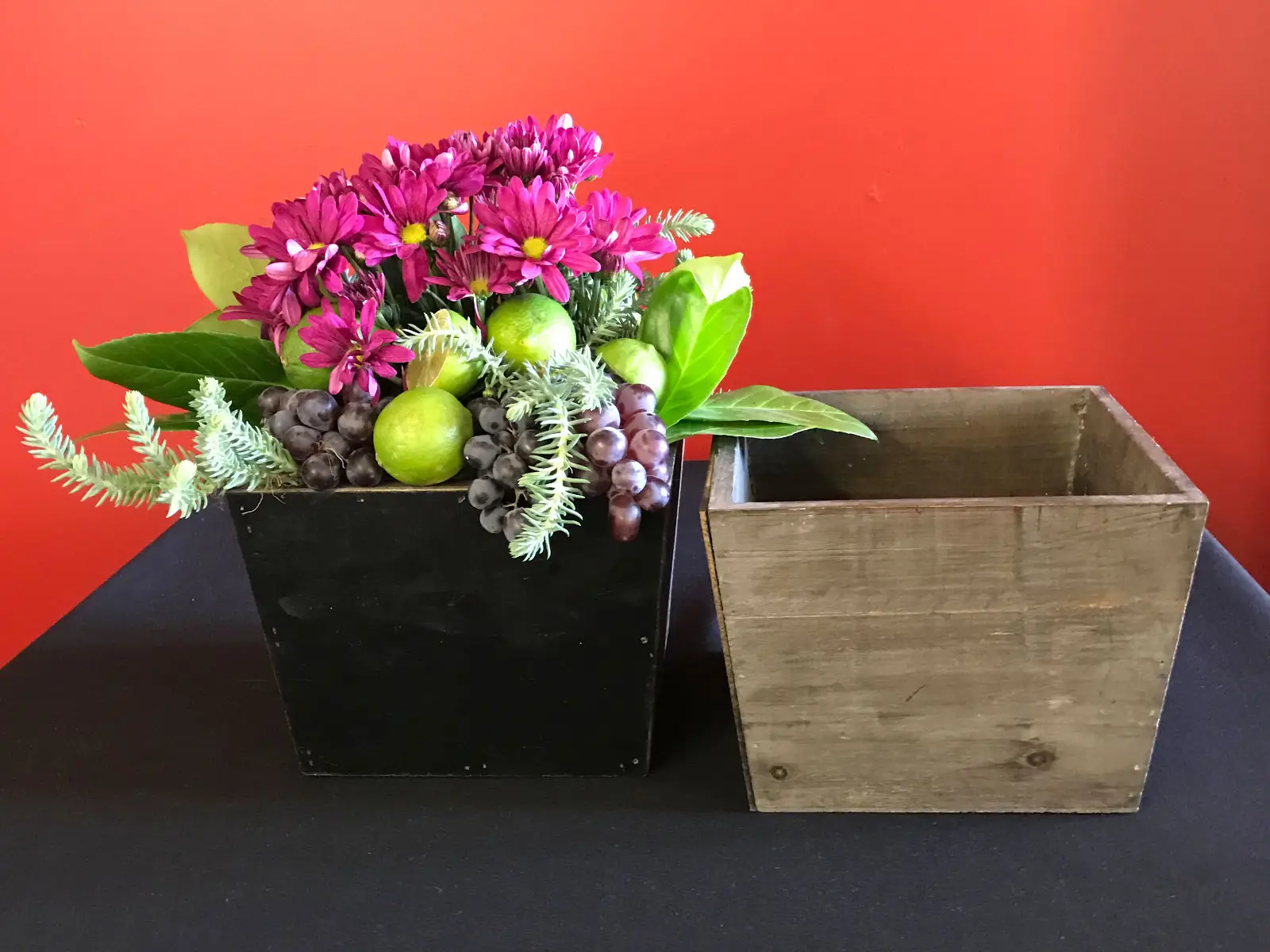 Purple flowers with green leaves, limes and grapes set in a grey box Purple flowers with green leaves, limes and grapes set in a grey box