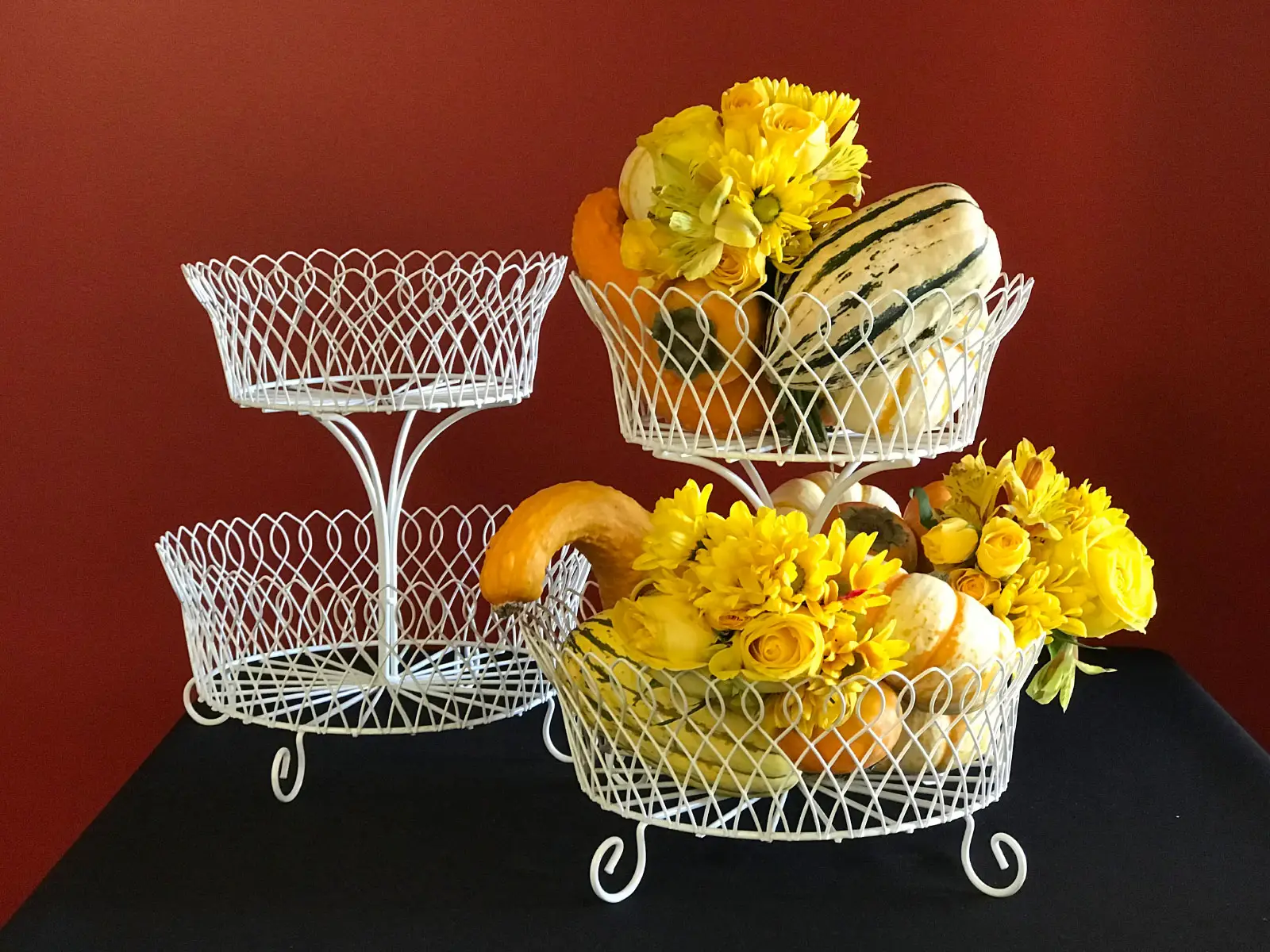 Several wax vegetable centerpieces including squash and pumpkins with flowers in white baskets Several wax vegetable centerpieces including squash and pumpkins with flowers in white baskets