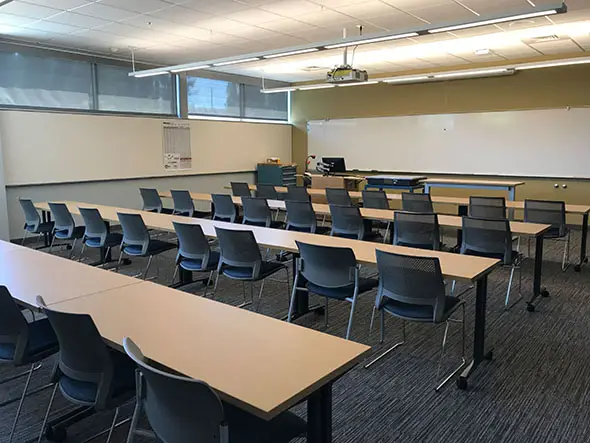 Several rows of tables and chairs in a classroom with a room-wide whiteboard in the Oregon City campus' Industrial Technology Center Several rows of tables and chairs in a classroom with a room-wide whiteboard in the Oregon City campus' Industrial Technology Center
