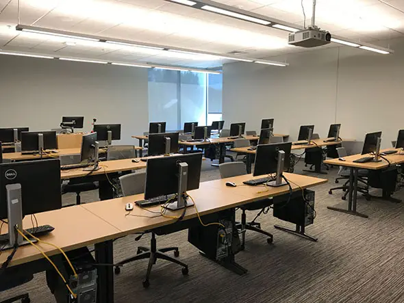 Rows of tables with silver chairs and computers in a windowed computer lab on the Oregon City campus Rows of tables with silver chairs and computers in a windowed computer lab on the Oregon City campus