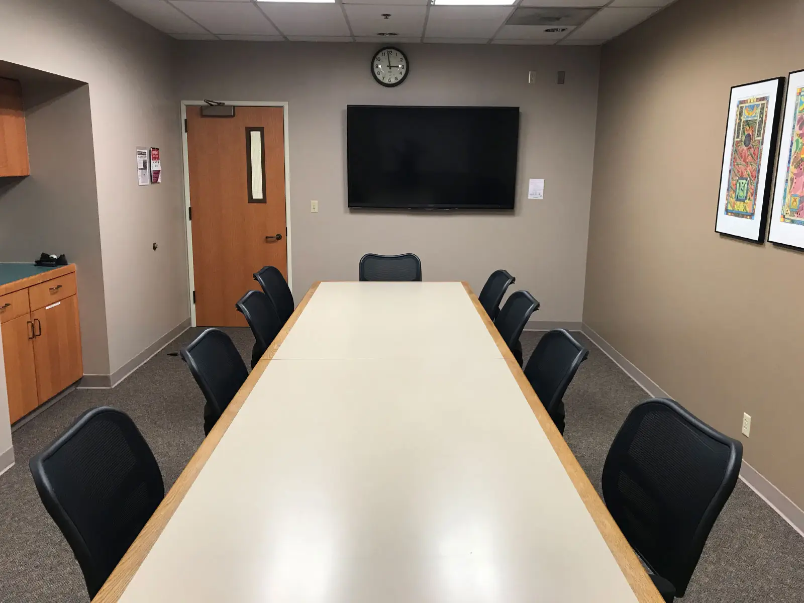 A long table with several chairs in a conference room with a TV display on the Oregon City campus