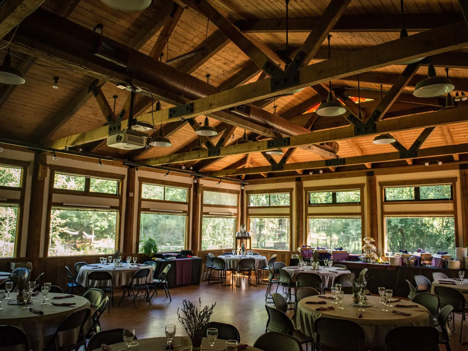 The inside of the Environmental Learning Center's Lakeside Hall, featuring decorated tables, glassware and catered drinks