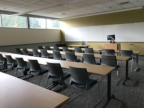 One of the Industrial Technology Center's many classrooms, featuring rows of chairs and table with a podium and room-wide whiteboard