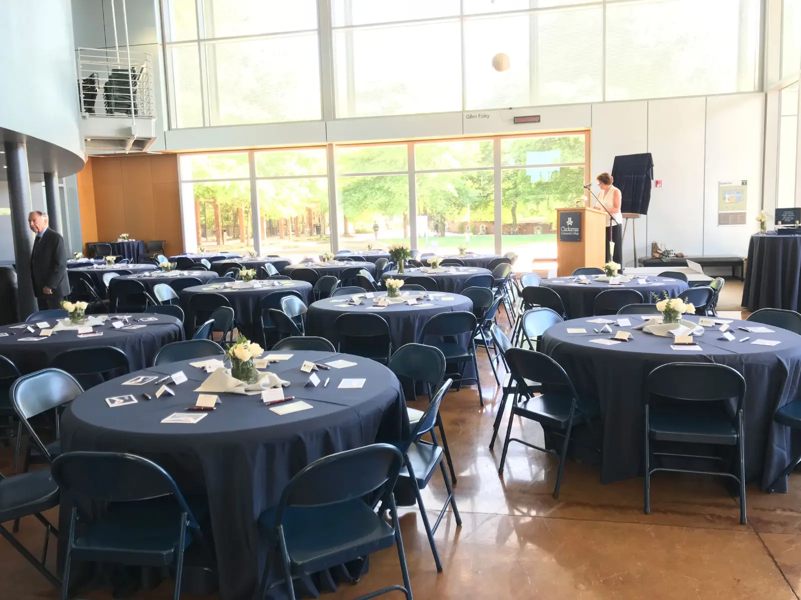 Decorated tables and podium for an event in Niemeyer Center's open lobby at the Oregon CIty campus Decorated tables and podium for an event in Niemeyer Center's open lobby at the Oregon CIty campus