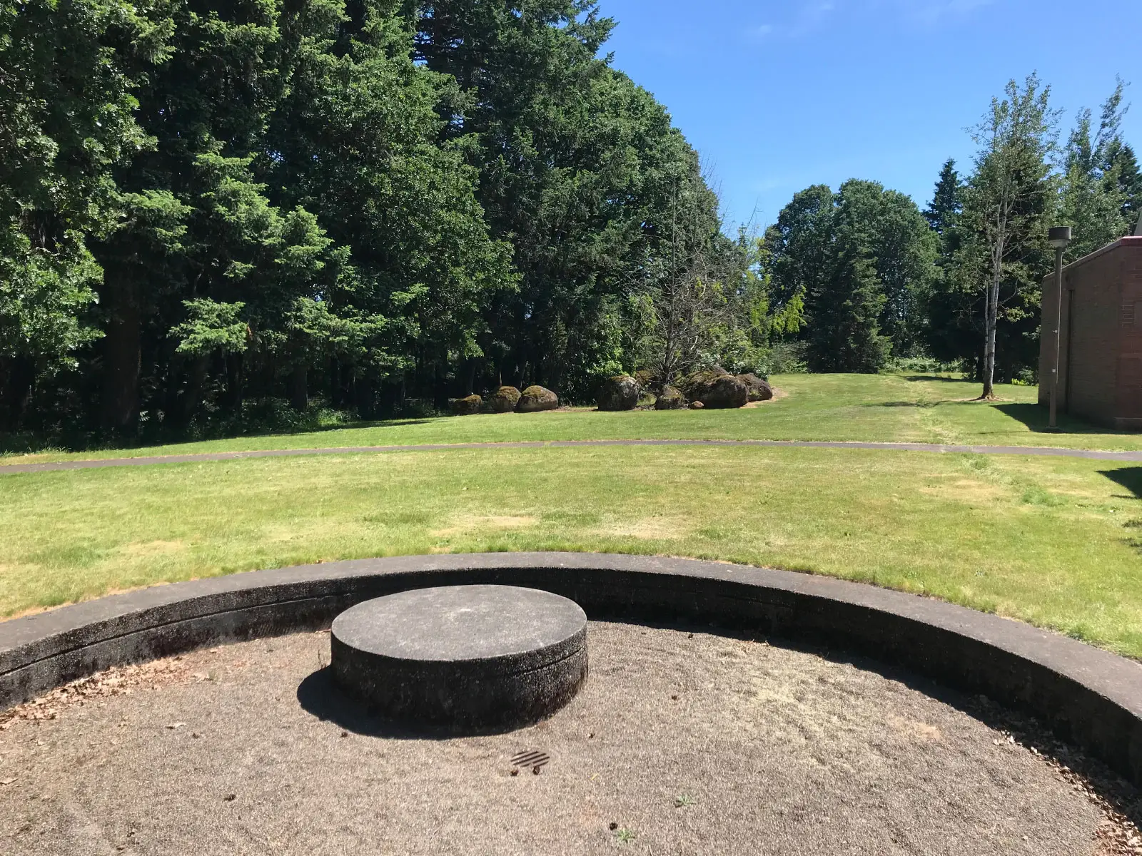 A circular, stone structure pit with sand in an open field on the Oregon City campus A circular, stone structure pit with sand in an open field on the Oregon City campus