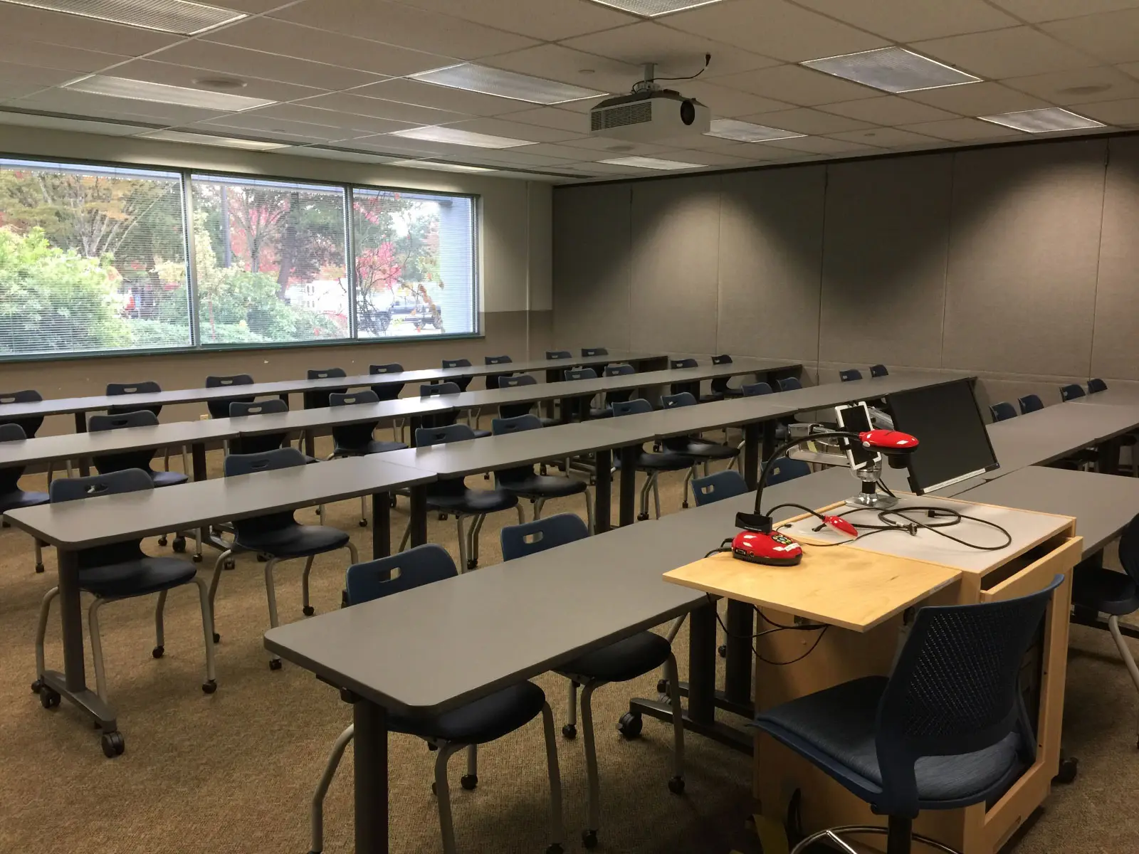 Rows of chairs and tables in front of a podium and projector in classroom W112 on the WIlsonville campus Rows of chairs and tables in front of a podium and projector in classroom W112 on the WIlsonville campus